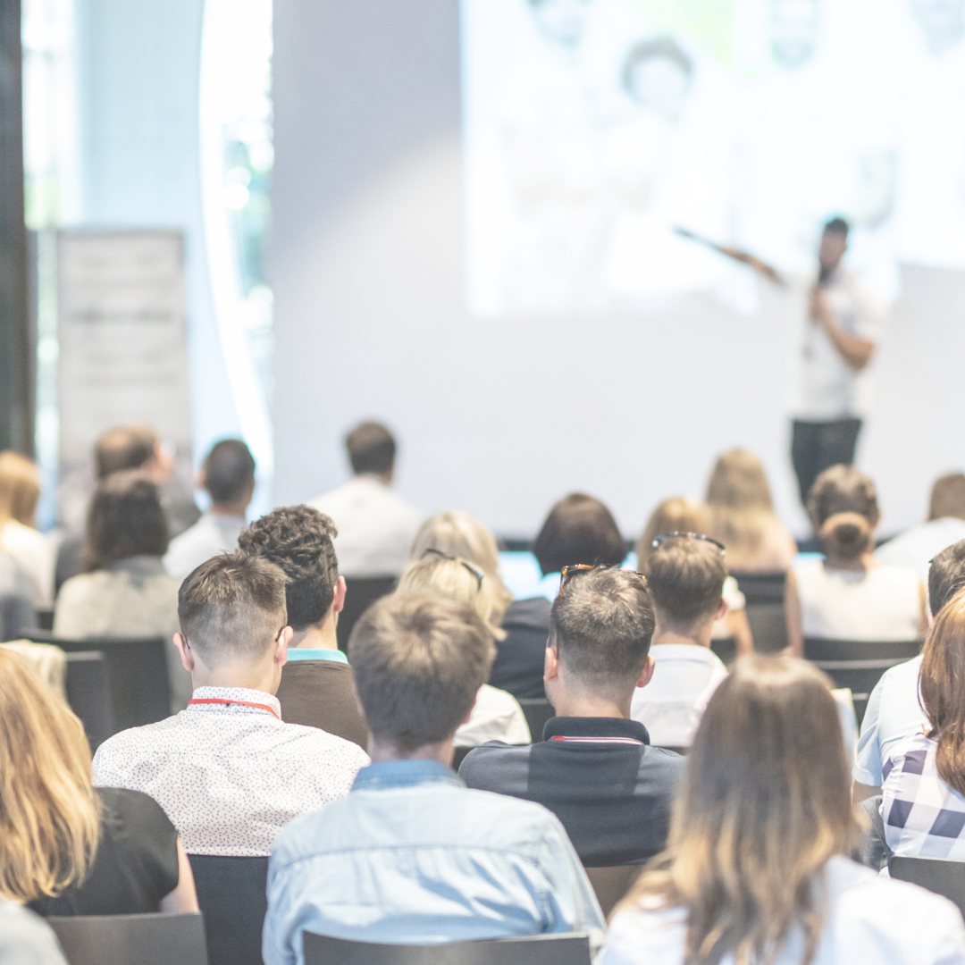 People sitting in an auditorium attending a conference session