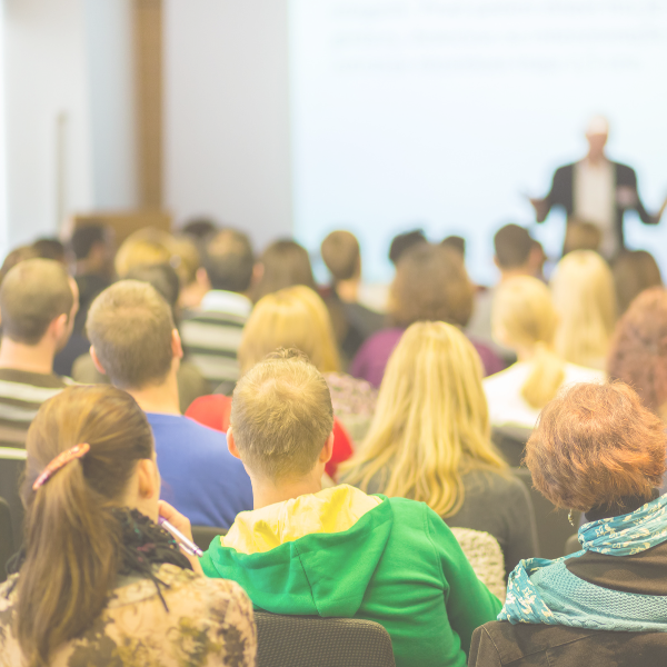 People sitting in an auditorium attending a conference session