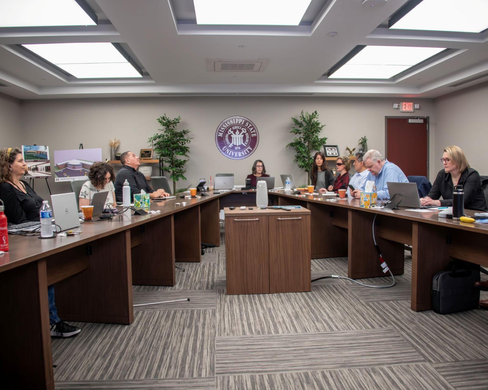 Council members sitting at conference table.