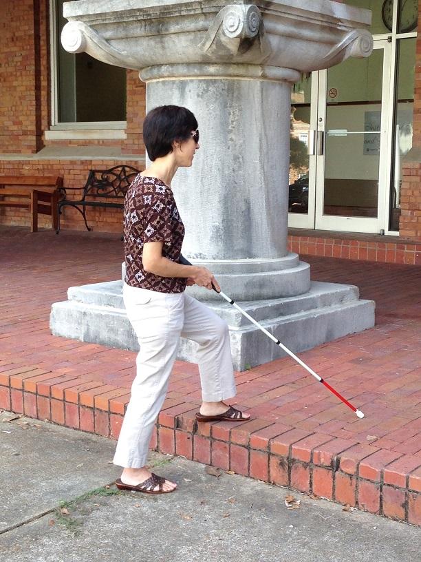 Kendra Farrow walking with a white cane