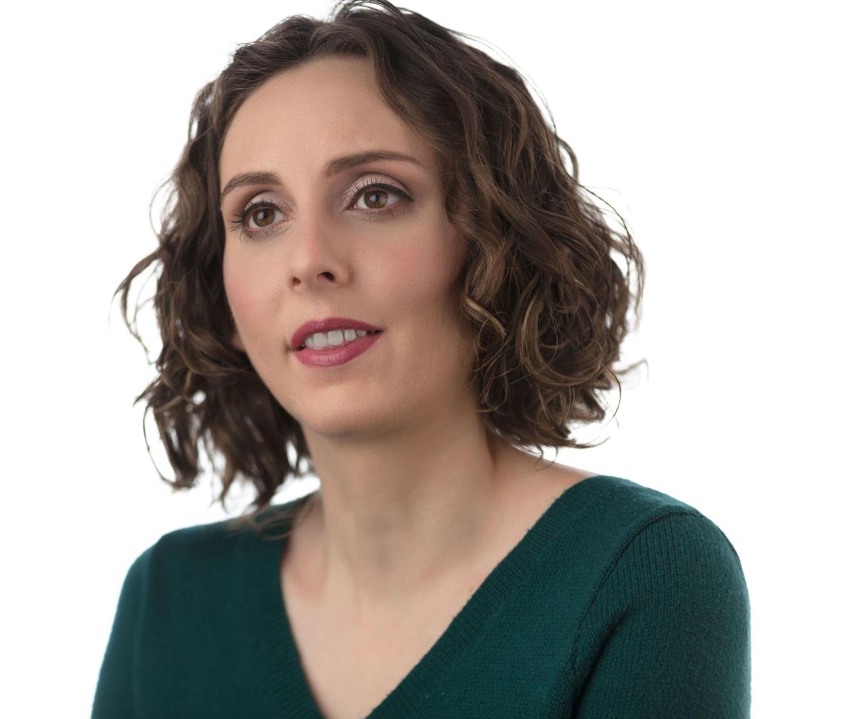 Headshot of Arielle. She is a white woman with short brown hair and is wearing a green blouse.